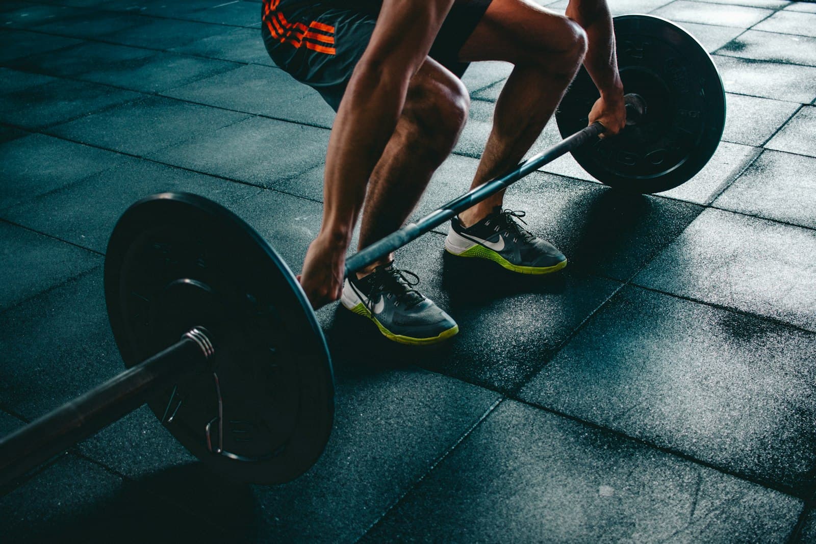 Neutral gym detail with a barbell — recovery and training rigor.